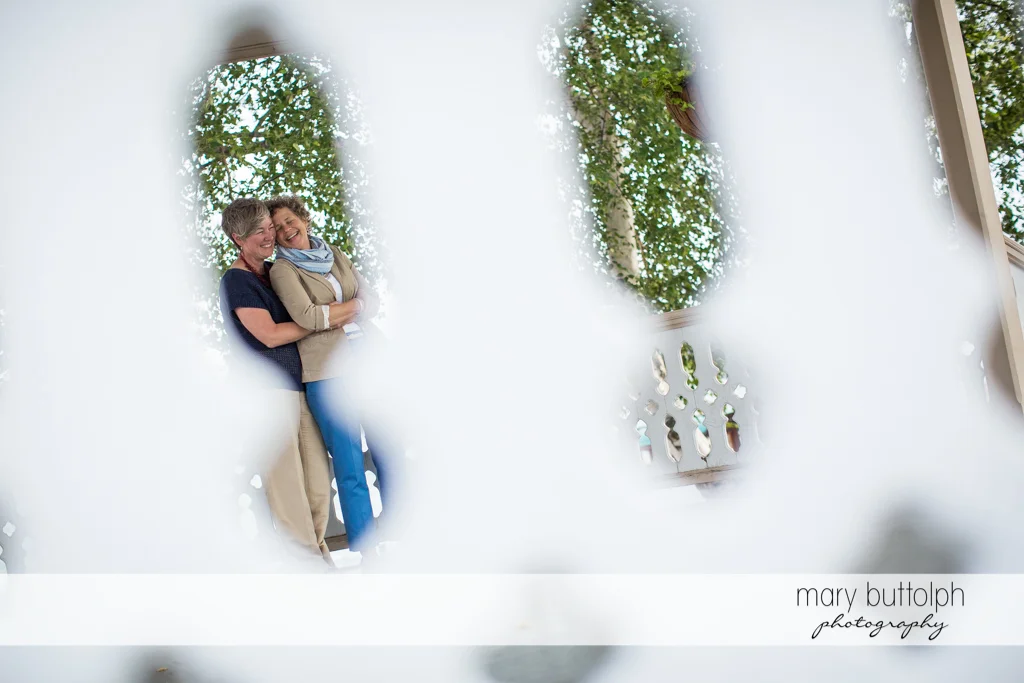 Same sex couple as seen through the fence at Skaneateles Lake Engagement