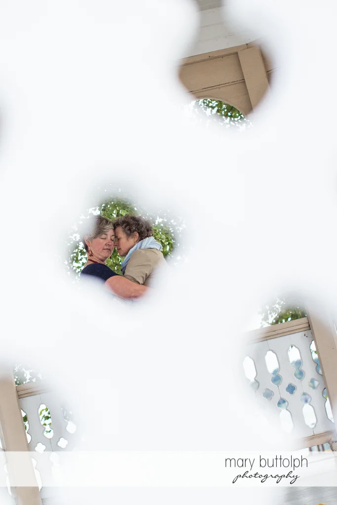Same sex couple viewed through the fence at Skaneateles Lake Engagement