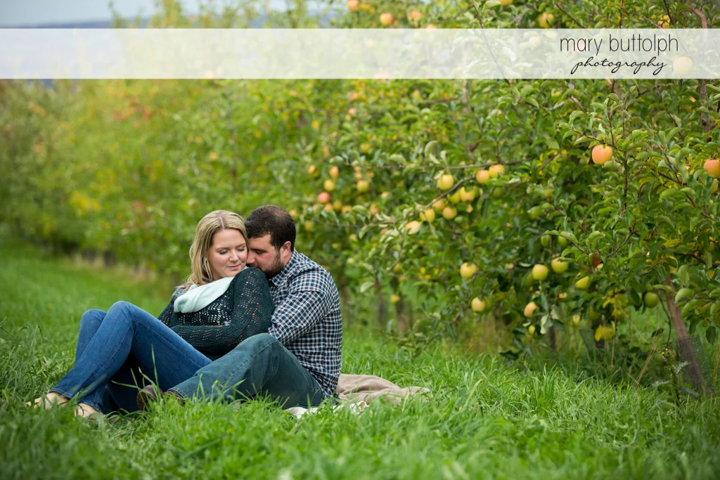 Couple relax in the garden near apples trees at Beak & Skiff Apple Orchards Engagement