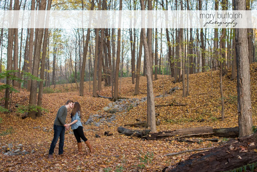 Couple kiss in the woods at Green Lakes Engagement