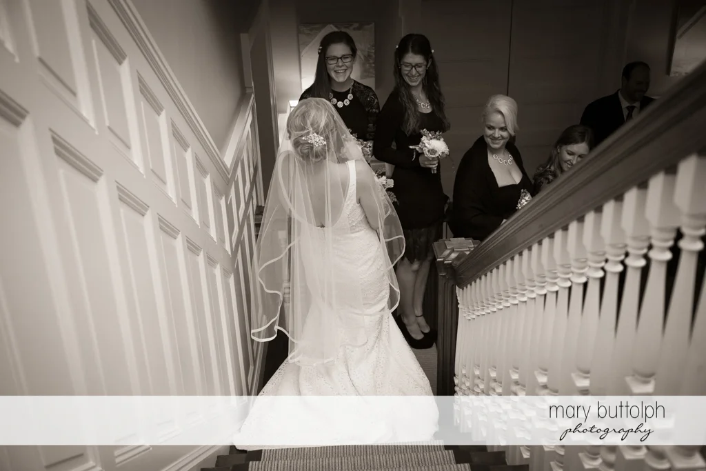 The bride and her bridesmaids go downstairs at Rowland House Wedding