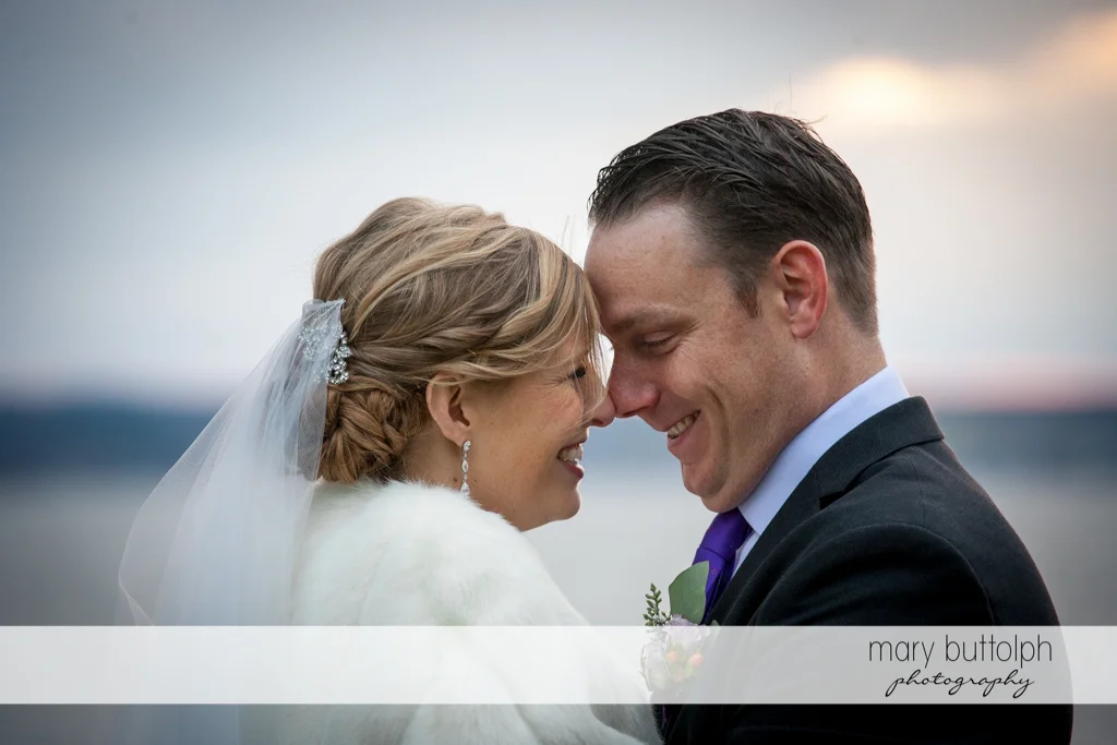 Couple rub noses by the lake at Rowland House Wedding
