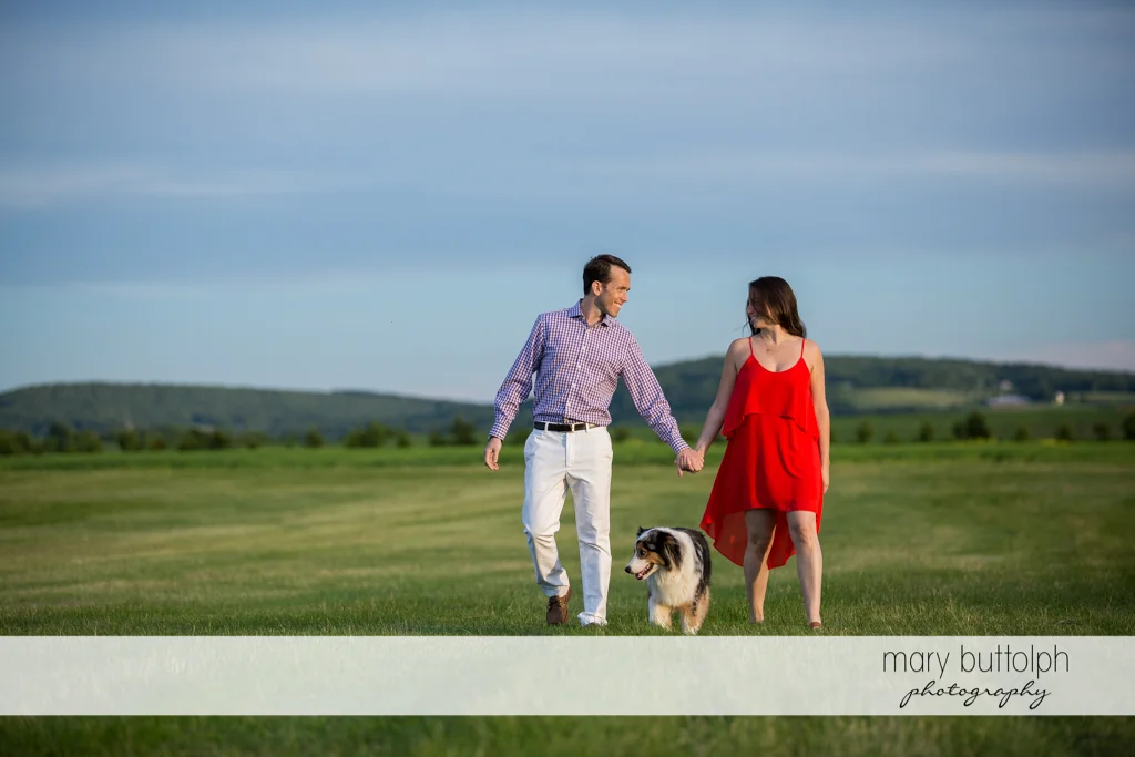 Couple stroll in the garden with their pet dog at Cazenovia Engagement