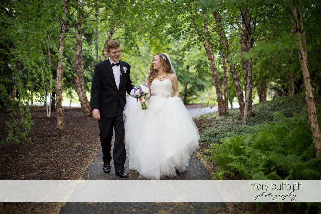 Couple stroll along the walkway in the garden at the Lodge at Welch Allyn Wedding