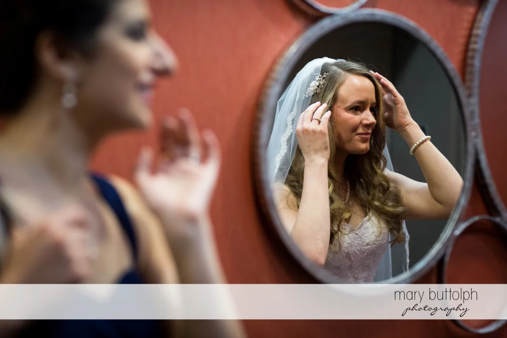 Brides adjusts her wedding veil at the Lodge at Welch Allyn Wedding