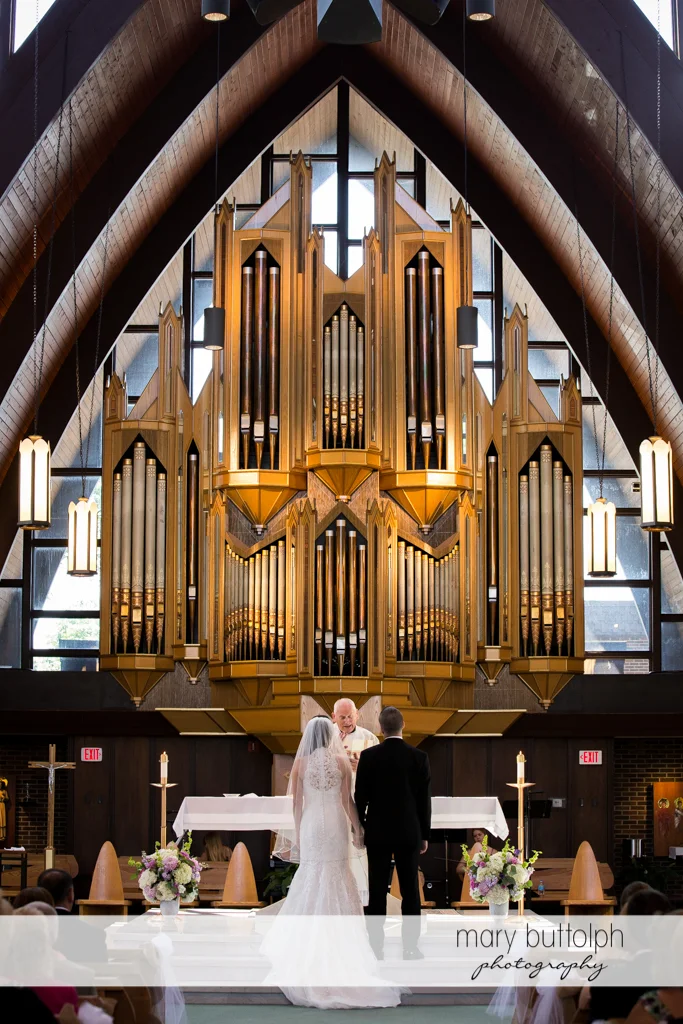 Couple listen to the priest at the Lodge at Welch Allyn Wedding