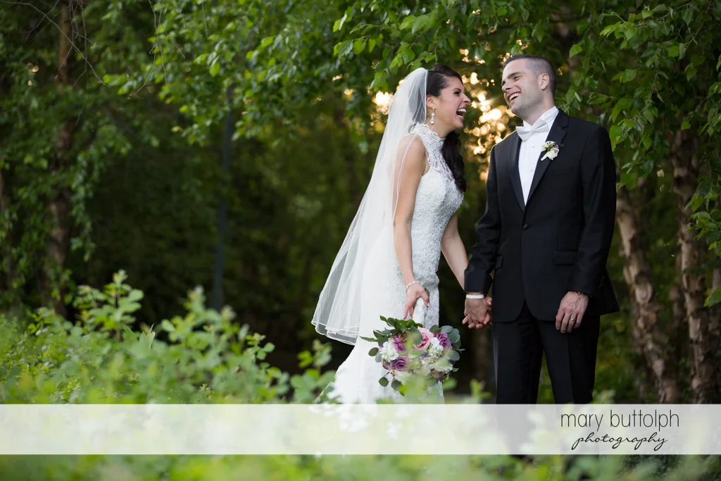 Couple find something funny in the garden at the Lodge at Welch Allyn Wedding