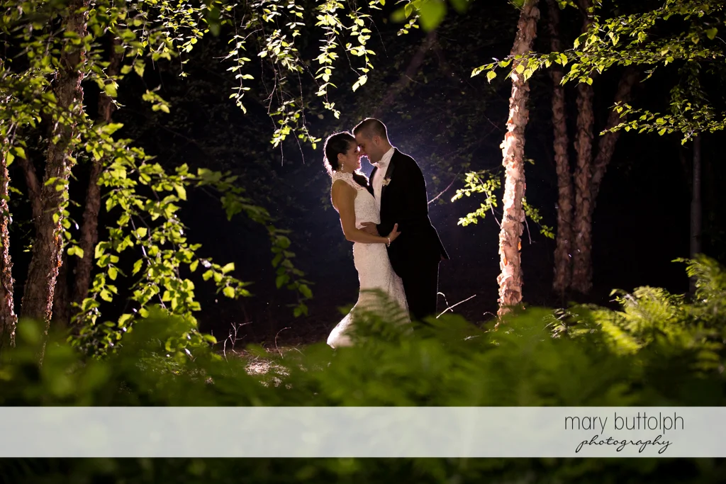Couple rub noses in the moonlight in the garden at the Lodge at Welch Allyn Wedding