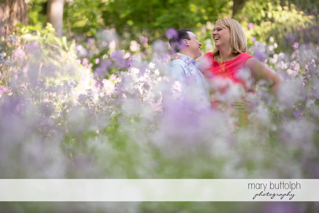 Couple surrounded by flowers at Skaneateles Lake Engagement