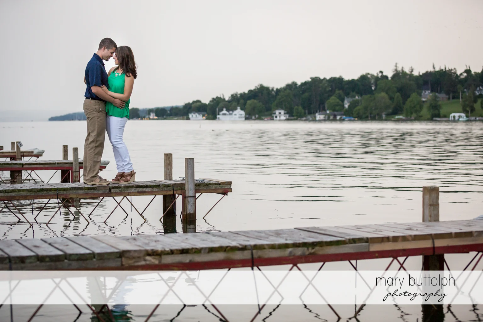 Couple hug by the lake at Skaneateles Engagement