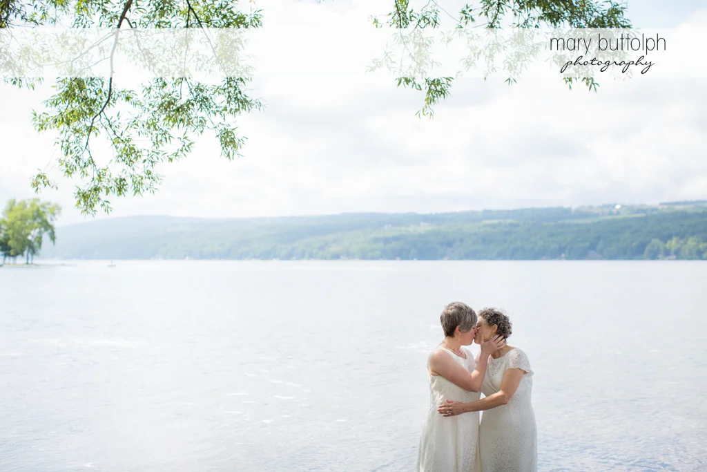Same sex couple kiss in the lake at Mandana Barn Wedding