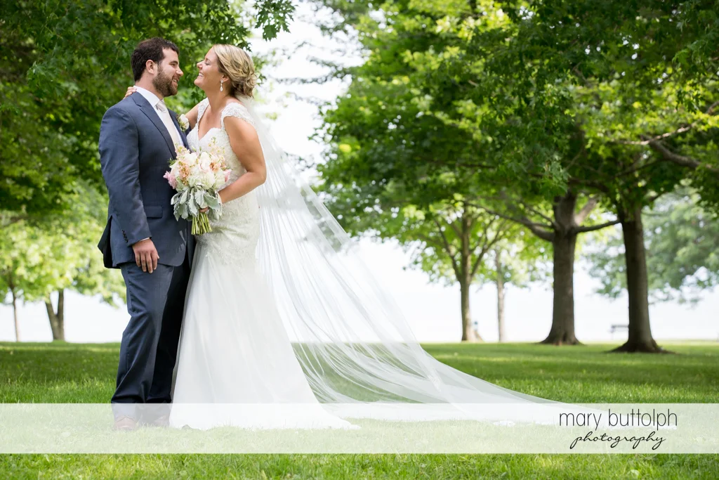 Couple share a tender moment in the garden partly covered by the wedding veil at Emerson Park Pavilion Wedding
