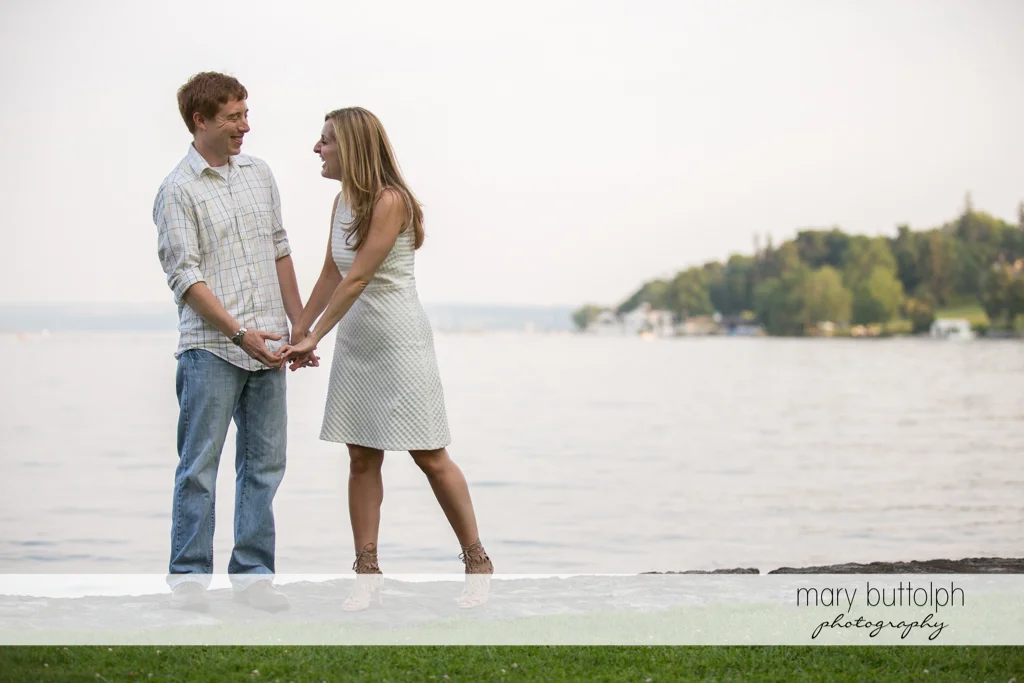 Couple stand by the lake at Skaneateles Engagement