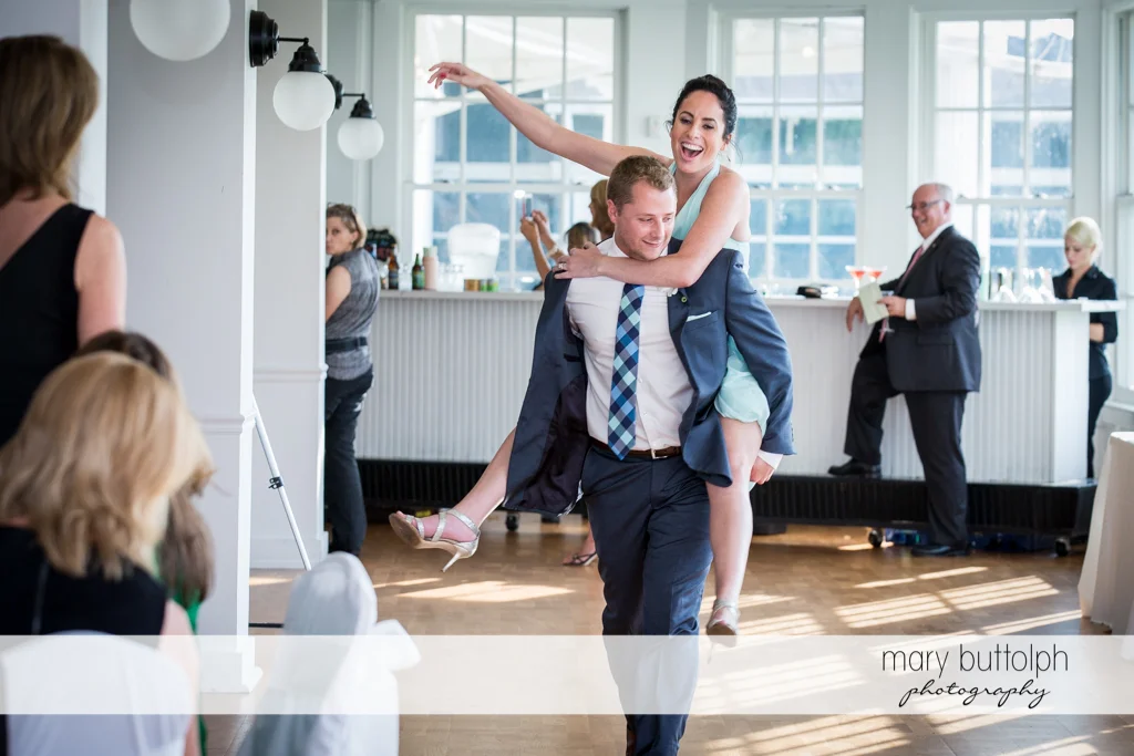Man gives woman a piggyback ride at Emerson Park Pavilion Wedding