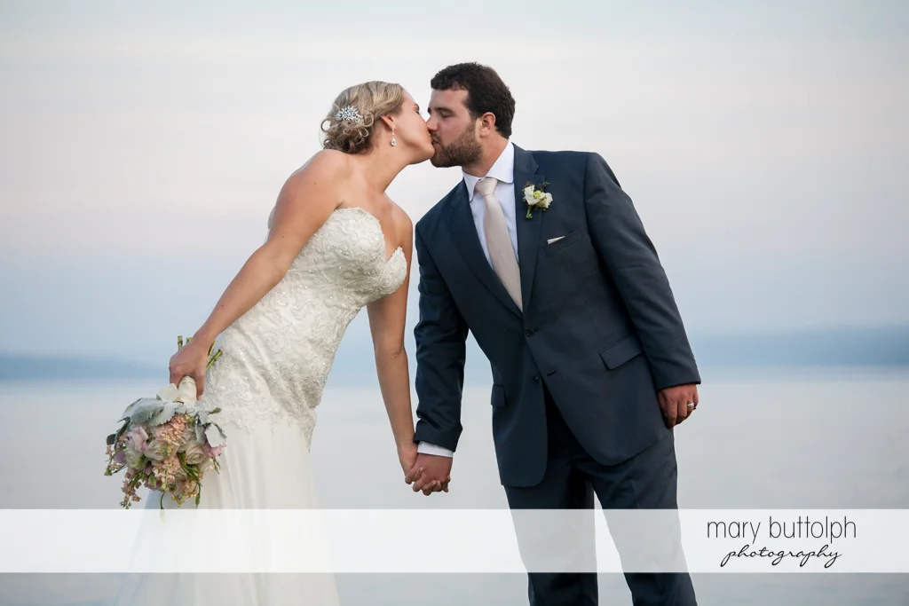 Couple share a kiss near the lake at Emerson Park Pavilion Wedding