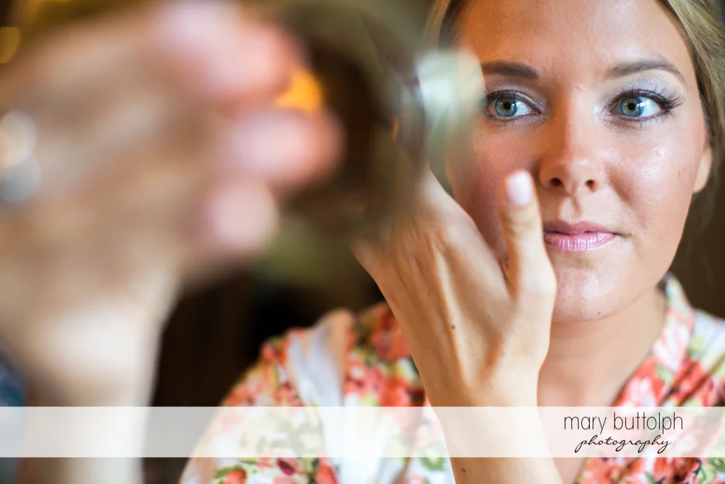 Bride checks her eye makeup at Emerson Park Pavilion Wedding