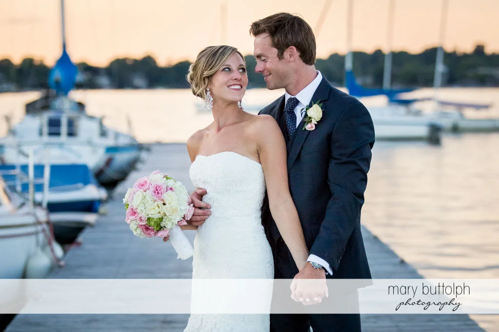 Couple hold hands on the docks at Skaneateles Country Club Wedding