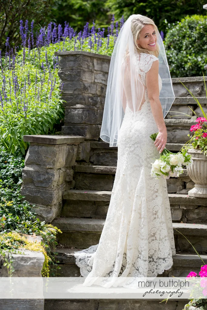Bride poses at the stone steps at Skaneateles Country Club Wedding