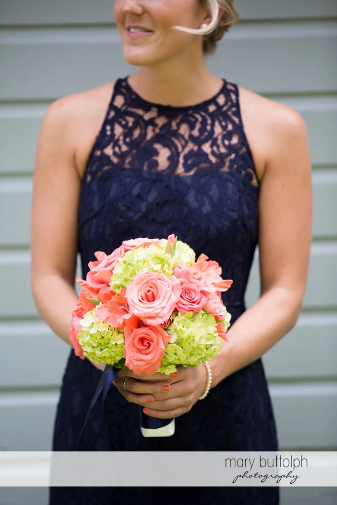 Bridesmaid in blue dress holding a bouquet at Turning Stone Resort Casino Wedding