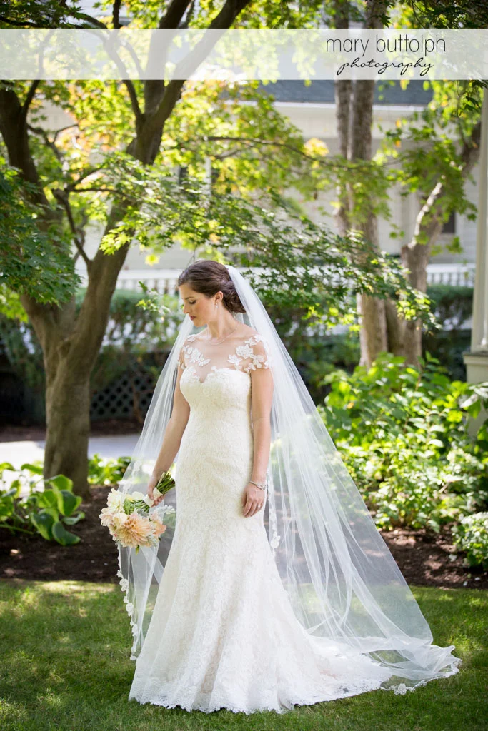 Bride with bouquet poses in the garden at Skaneateles Country Club Wedding