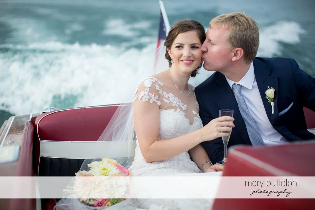 Groom kisses bride on the boat at Skaneateles Country Club Wedding