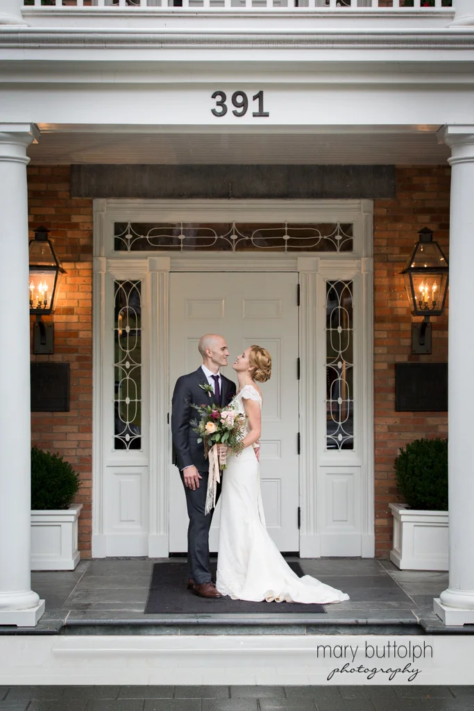 Couple stand in front of a door at the Inns of Aurora Wedding