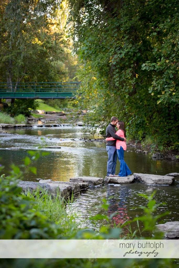 Couple embrace by the lake at Marcellus Engagement