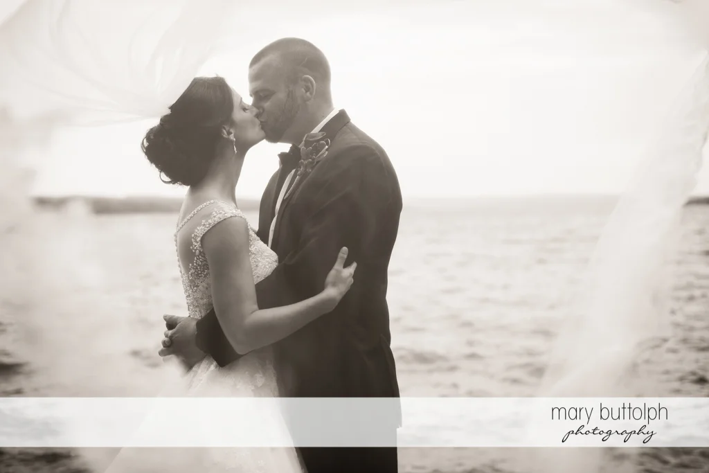 Couple kiss in front of the lake at Anyela's Vineyards Wedding
