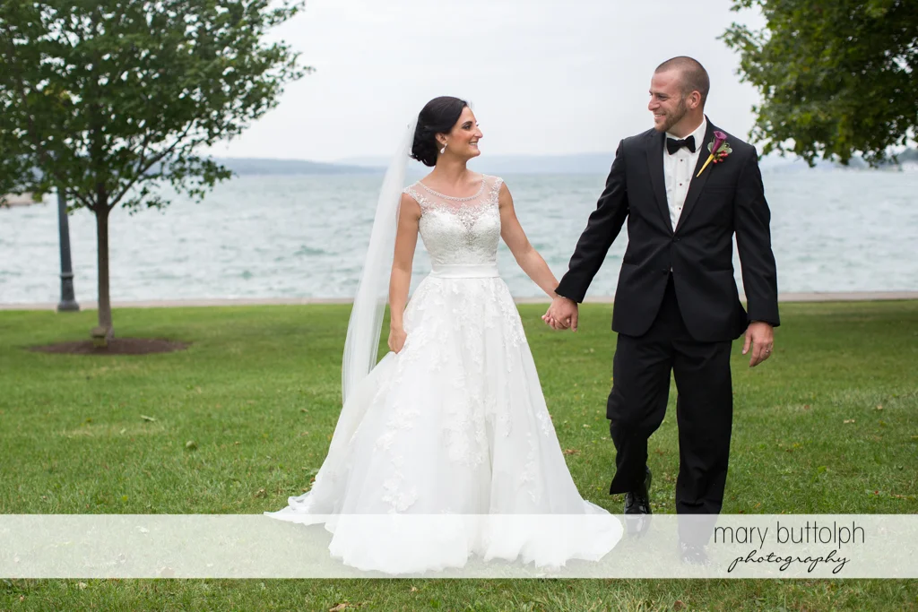 Couple walk hand in hand in the garden near the lake at Anyela's Vineyards Wedding