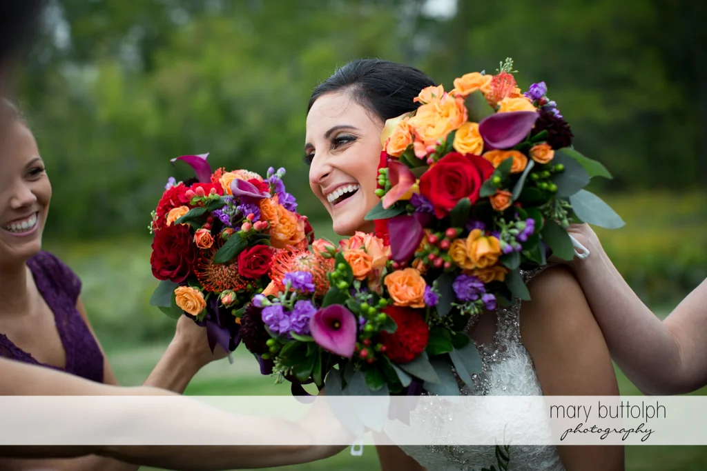 Bridesmaids surround bride's face with flowers at Anyela's Vineyards Wedding