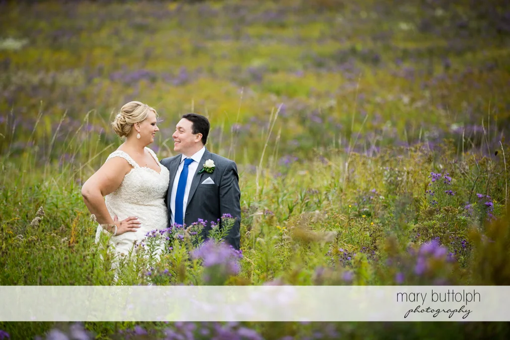 Couple share a happy moment in the meadow at the Lodge at Welch Allyn Wedding