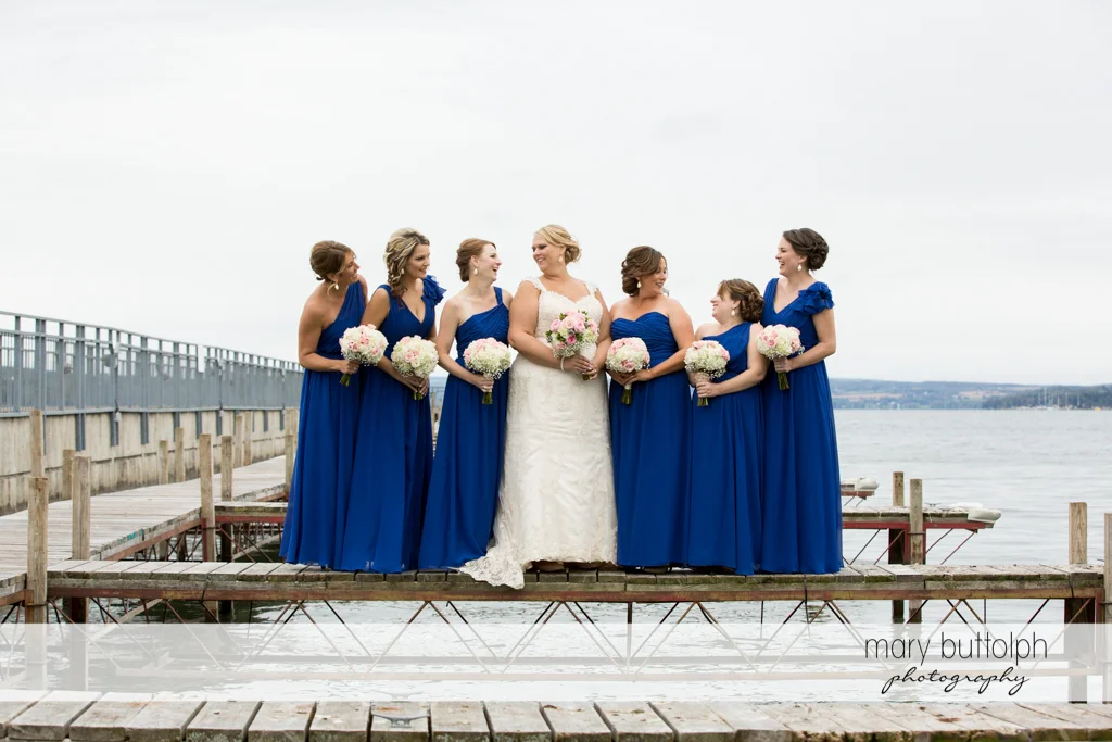 Bride and bridesmaids with bouquets at the docks at the Lodge at Welch Allyn Wedding