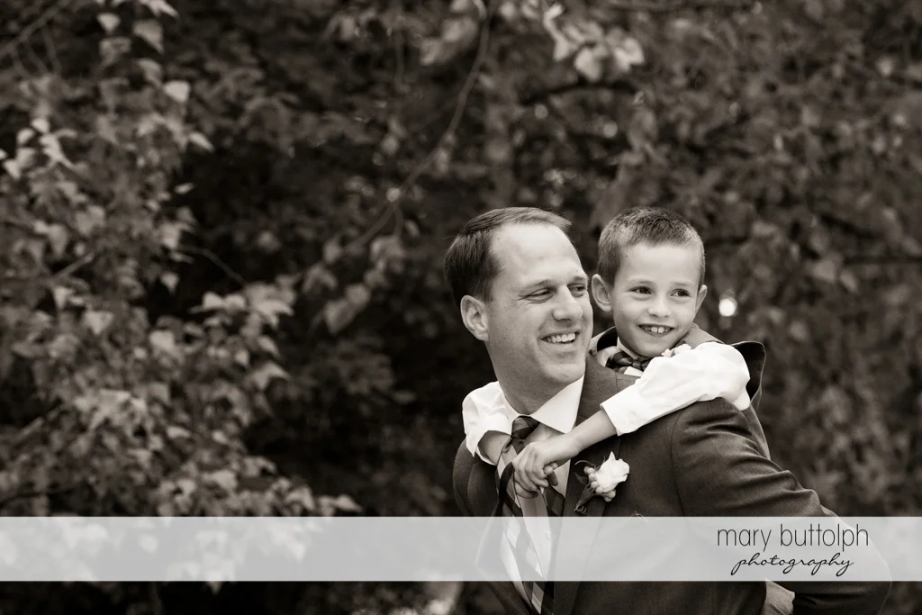 Boy gets a piggyback ride from one of the groomsmen at the Lodge at Welch Allyn Wedding