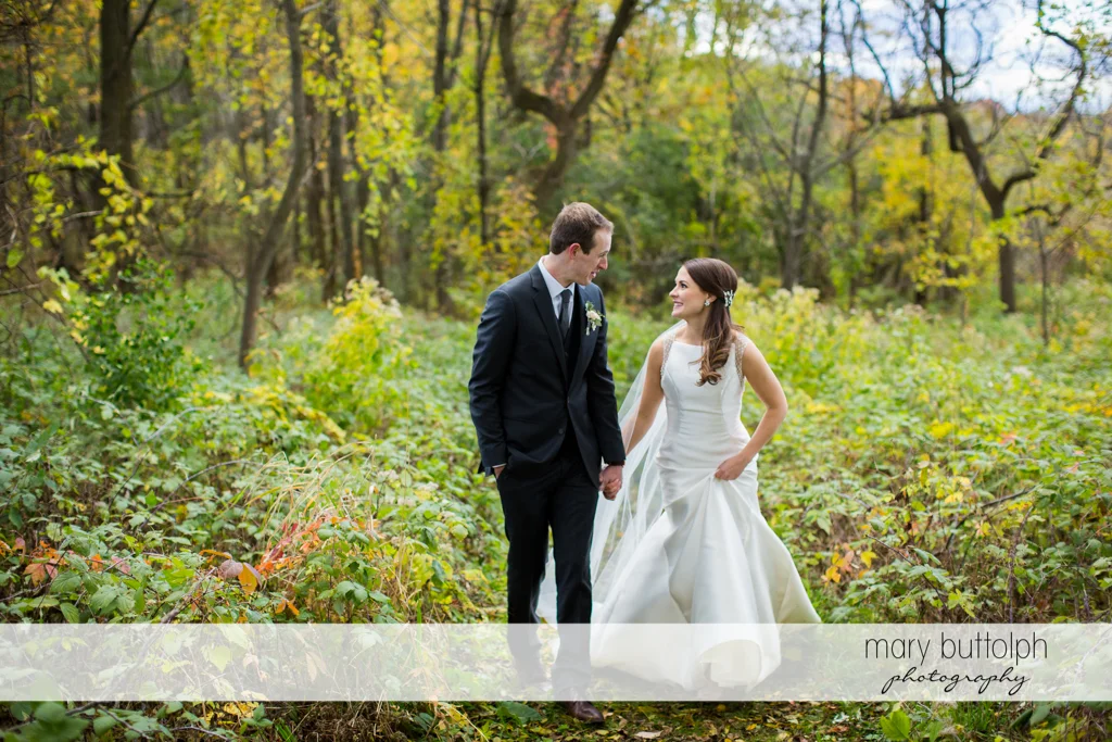 Couple stroll in the woods at Frog Pond Bed & Breakfast Wedding