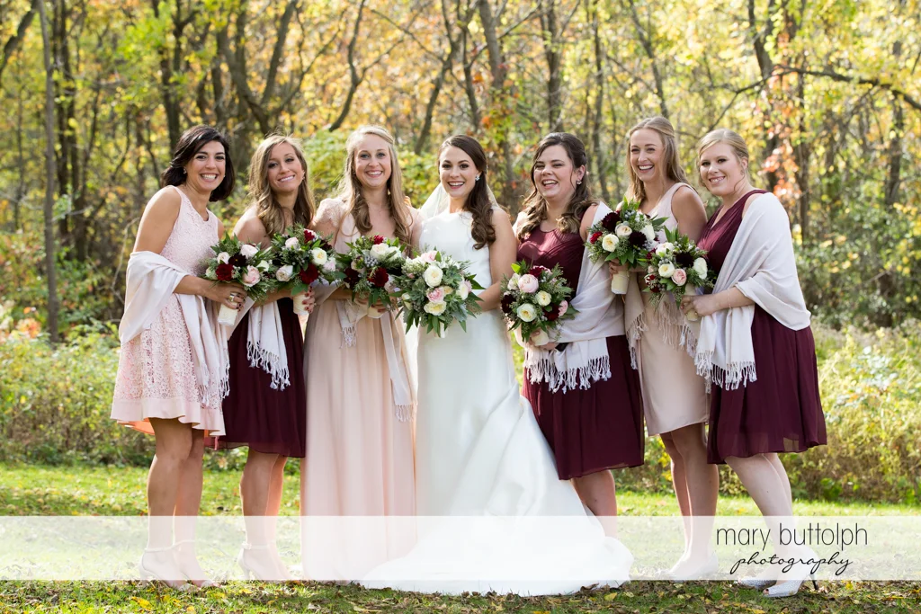 Bride and her bridesmaids with bouquets are photographed together at the Frog Pond Bed & Breakfast Wedding