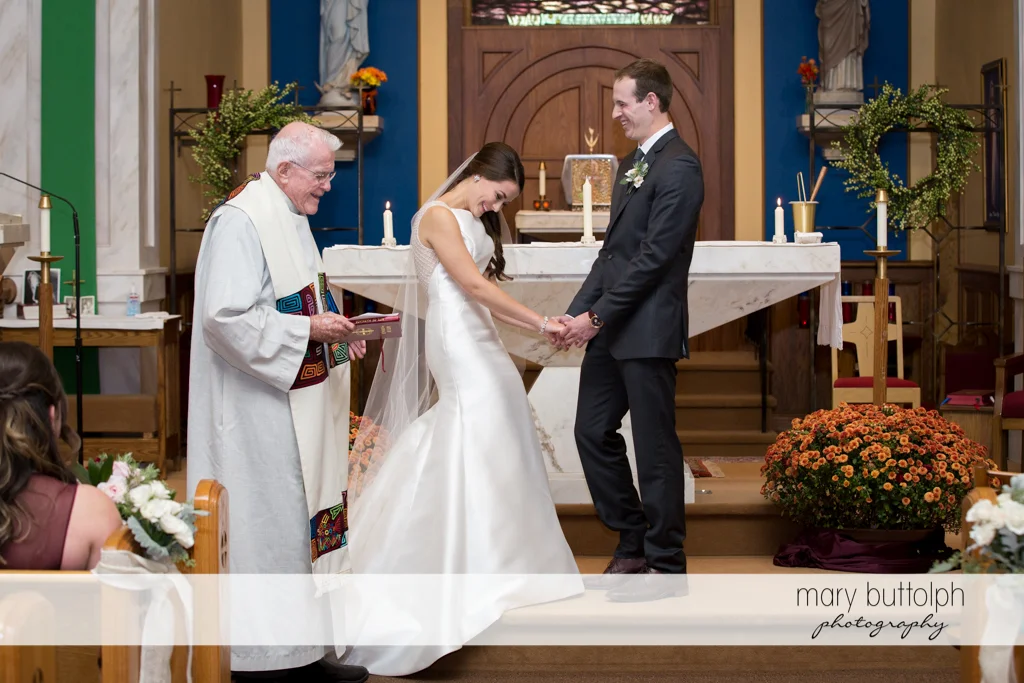 Couple and priest in front of the altar at the Frog Pond Bed & Breakfast Wedding