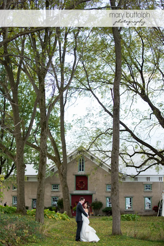 Couple stand in front of the carriage barn at the Frog Pond Bed & Breakfast Wedding