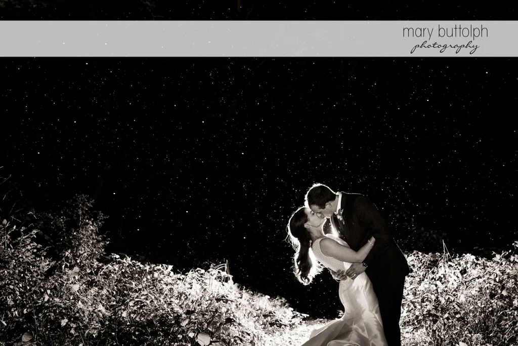 Couple kiss in the garden on a starry night at the Frog Pond Bed & Breakfast Wedding