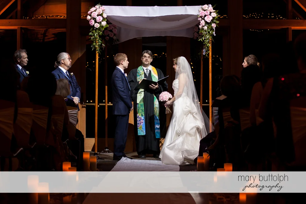 Couple and priest at the wedding ceremony at the Lodge at Welch Allyn Wedding