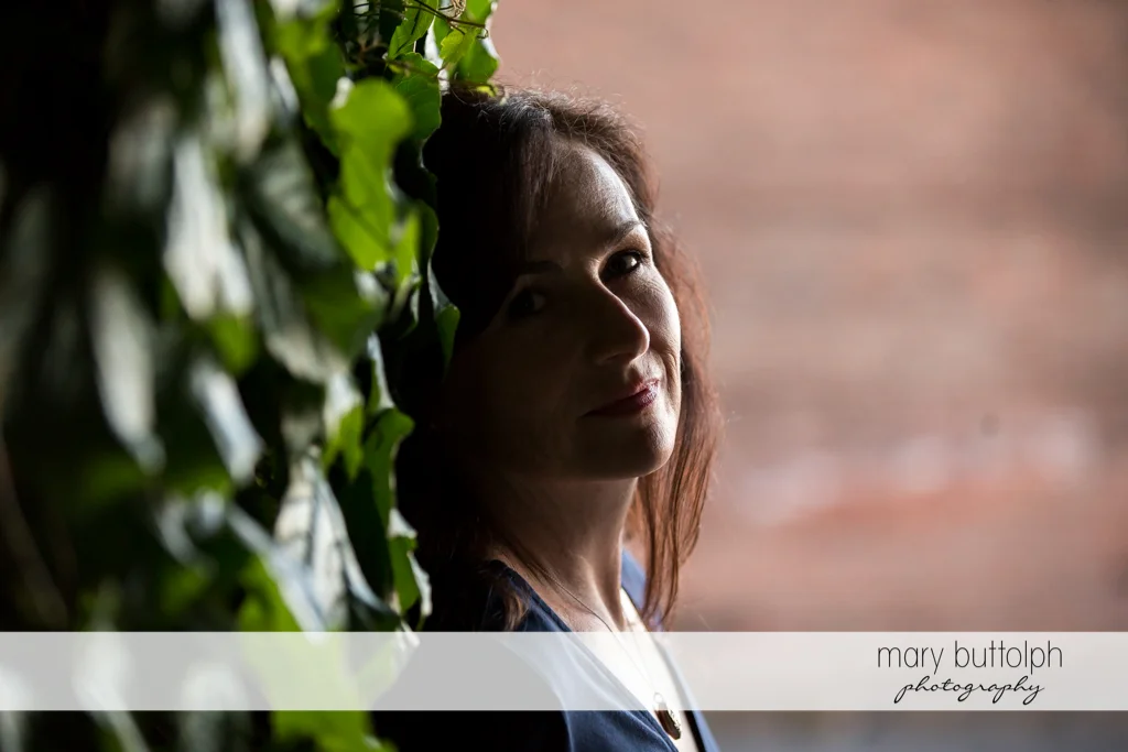 Woman's face is partly covered by shadows in the park at Skaneateles Engagement