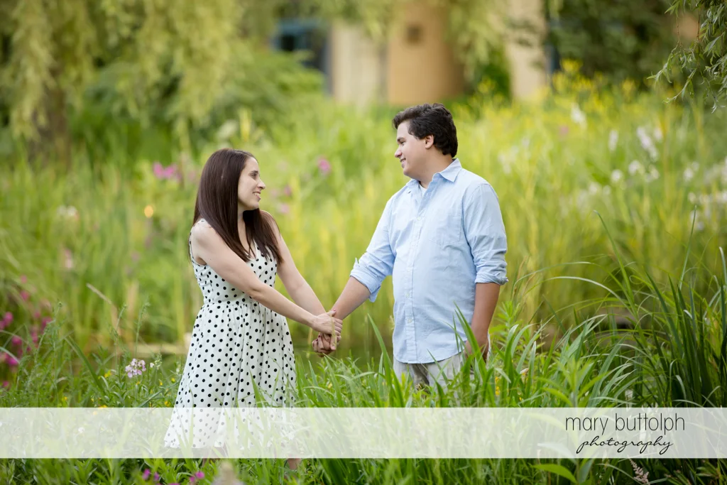 Couple hold hands in garden at Skaneateles Engagement