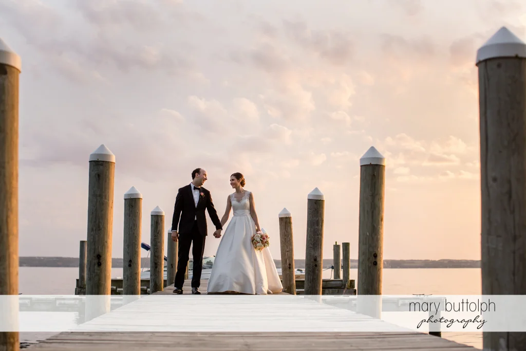Couple stroll on the dock at the Inns of Aurora Wedding