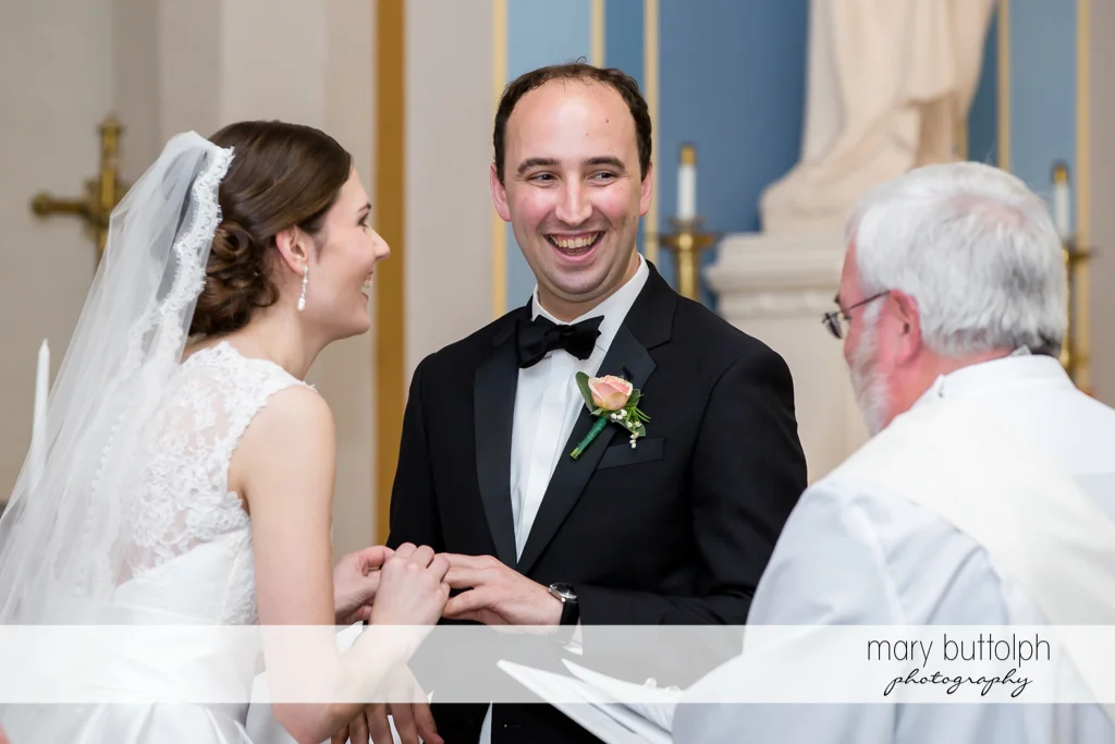 Couple hold hands in front of the priest at the Inns of Aurora Wedding