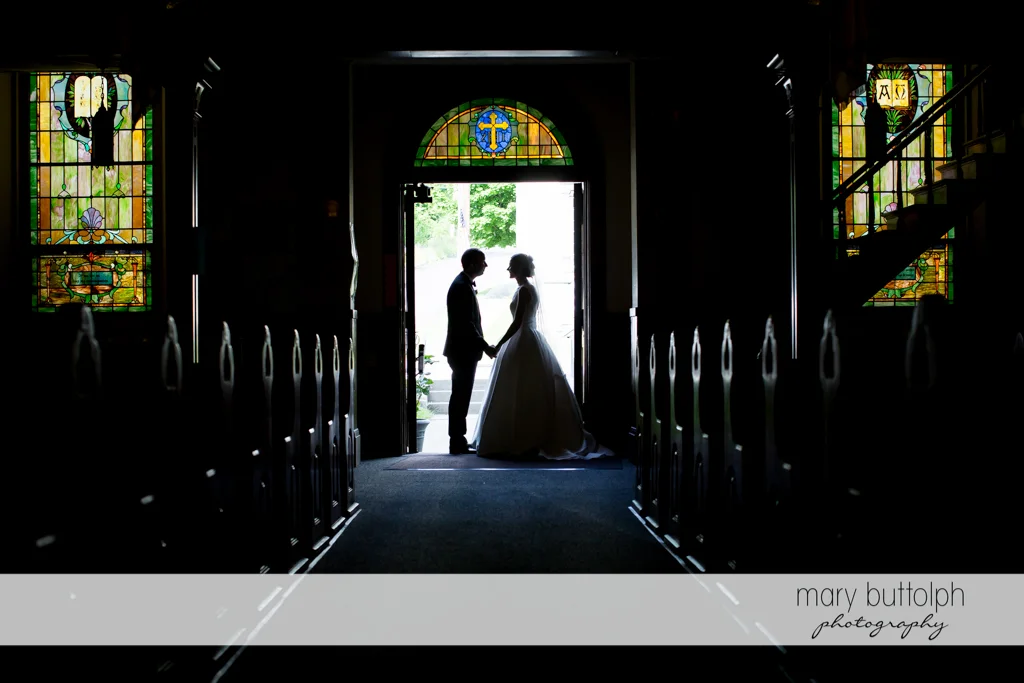 Couple stand on the church doorway at the Inns of Aurora Wedding