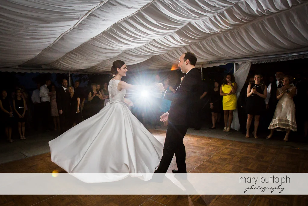 Couple dance as guests look on in the wedding tent at the Inns of Aurora Wedding