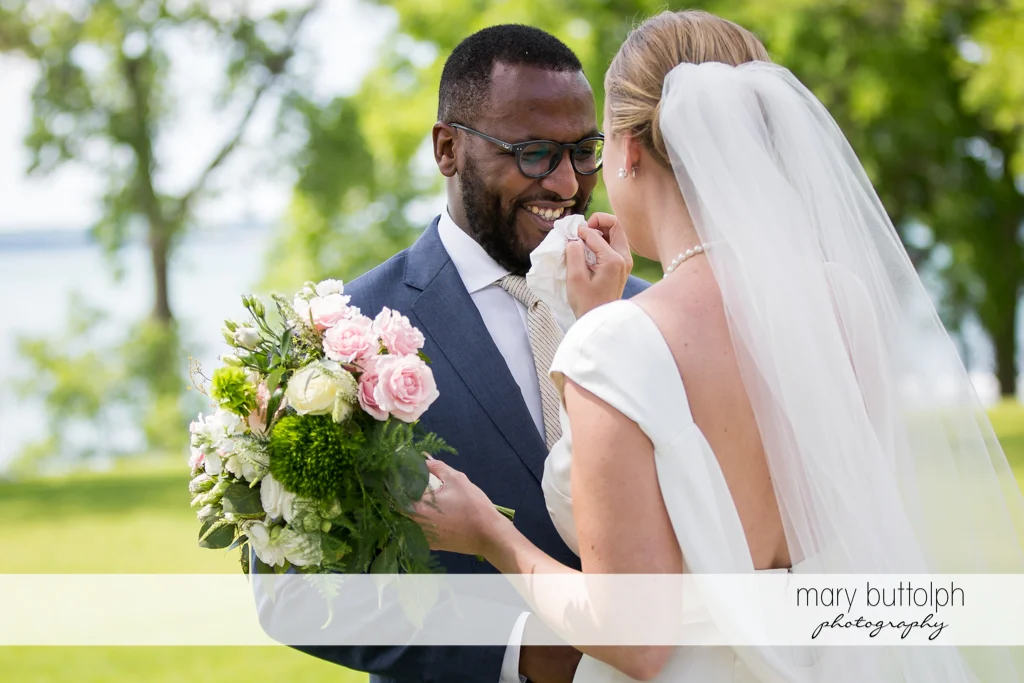 Bride wipes groom's lips in the garden at the Inns of Aurora Wedding