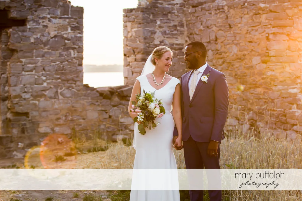 Couple pose in front of a brick structure at the Inns of Aurora Wedding