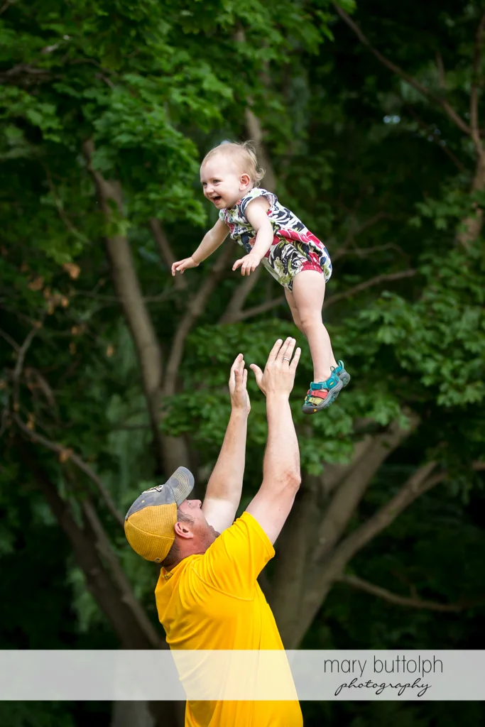 Man throws girl up in the air at Skaneateles Lake Vacation
