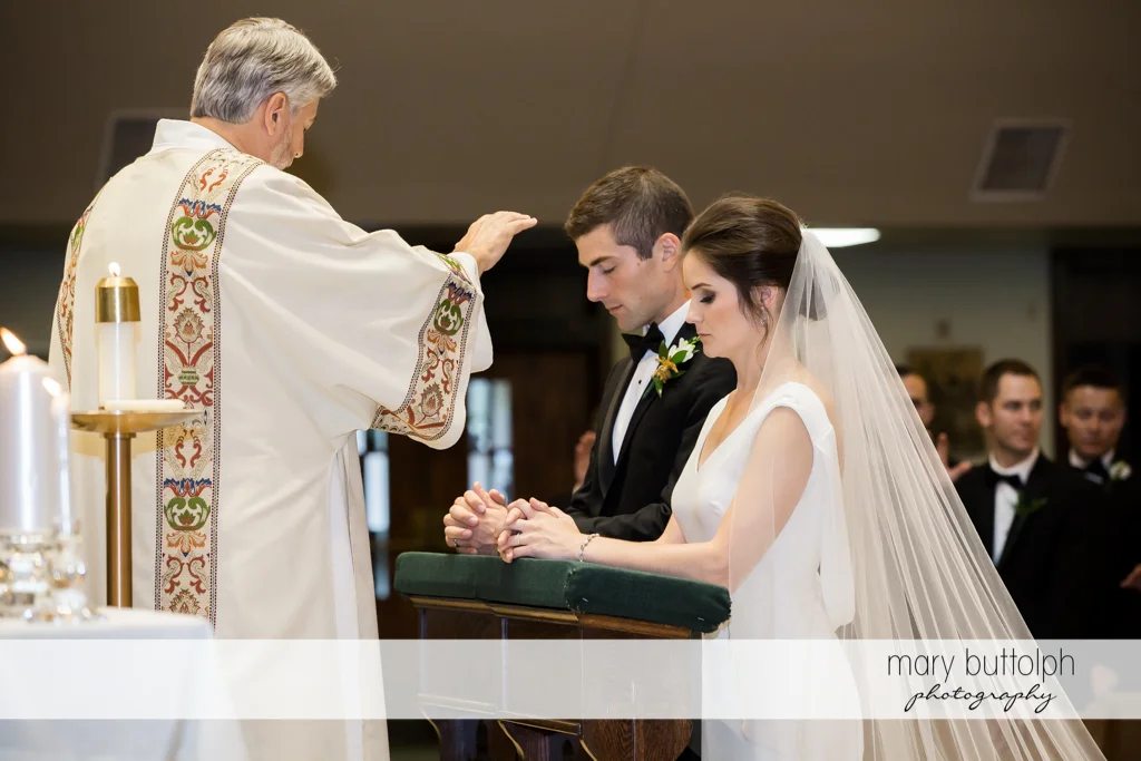 Couple are blessed by the priest at Genesee Grande Hotel Wedding