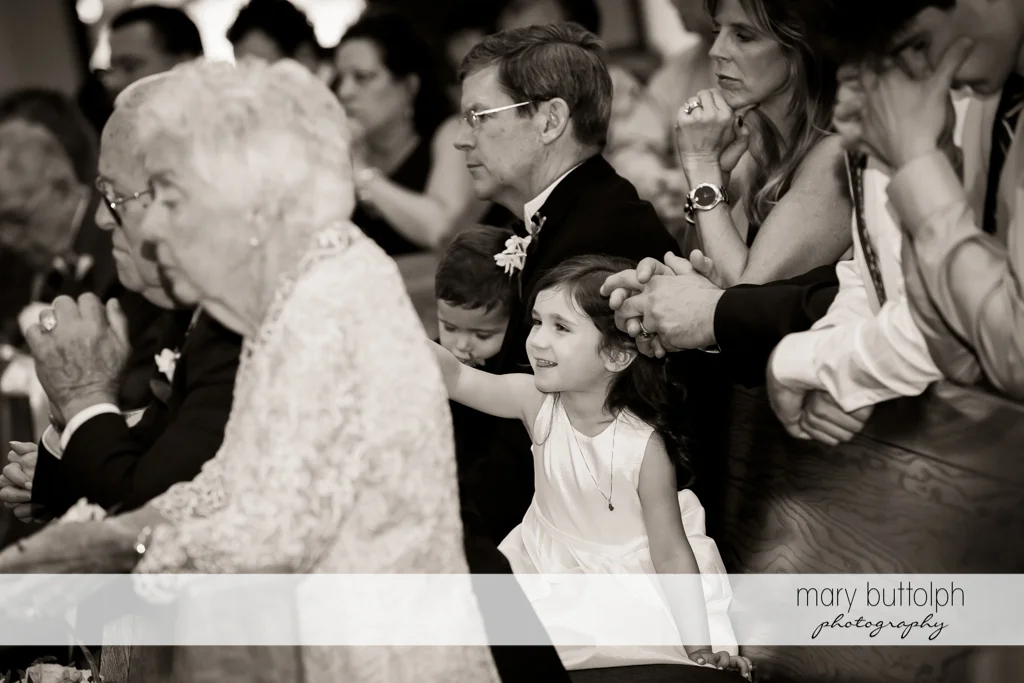Girl smiles as the people around her pray at Genesee Grande Hotel Wedding